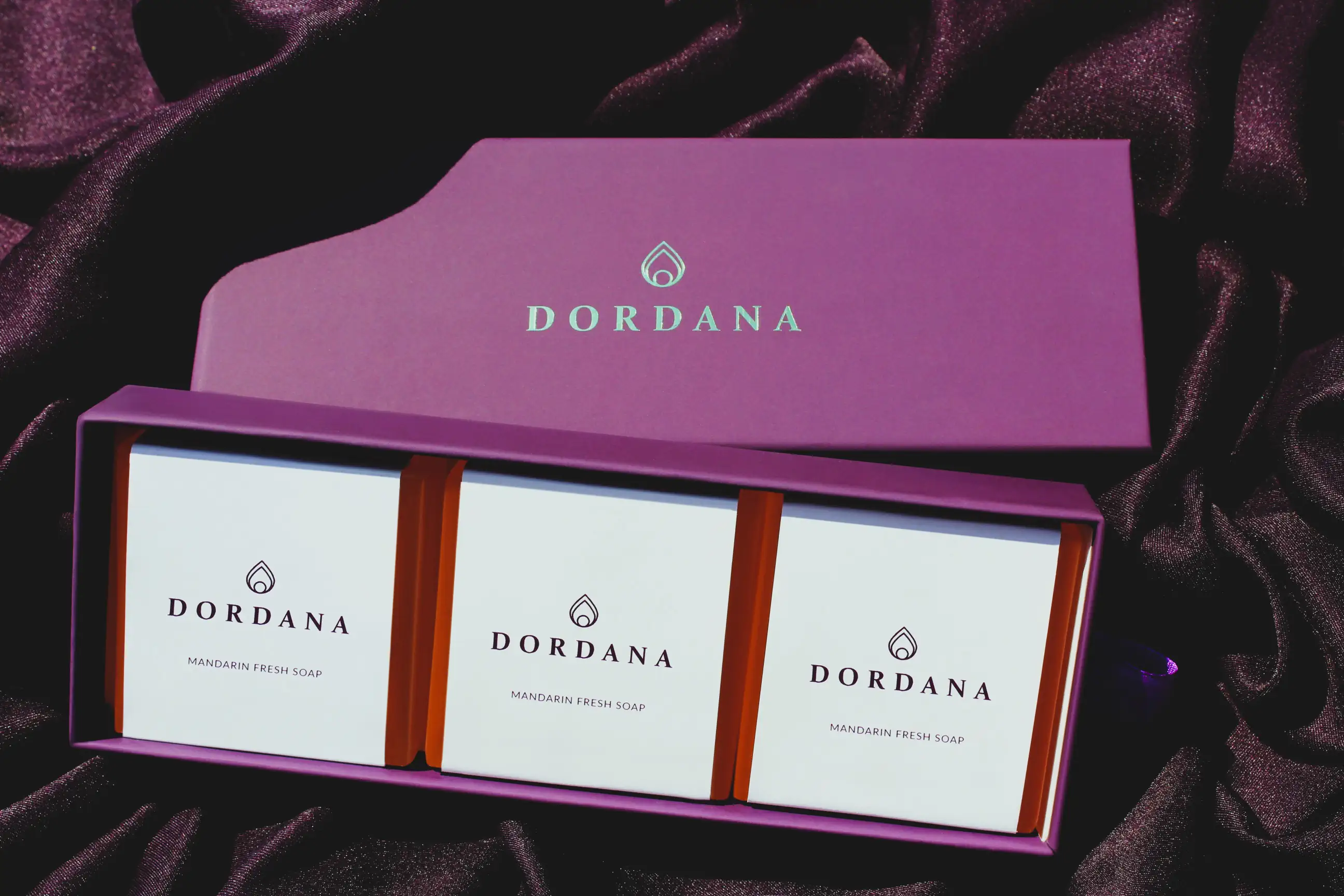 The three Dordana soap bars of the Mandarin Fresh Trio comfortably housed in their purple presentation box on a hot summer's day.
